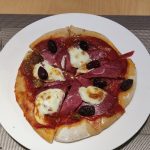 Red pizza with salami, peperoni and olives. Rote Pizza mit Salami, Peperoni und Oliven.