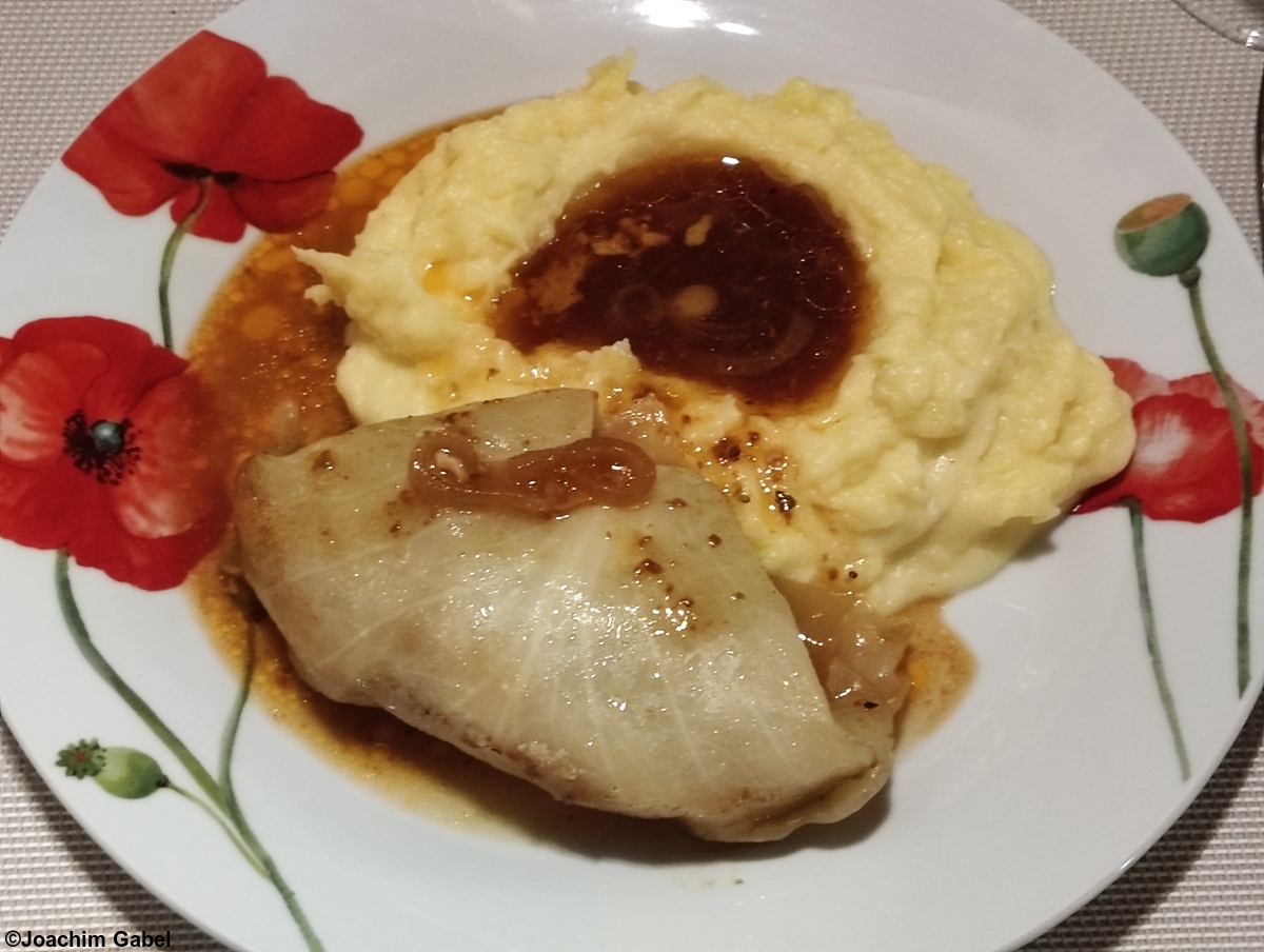 Cabbage roll with mashed potatoes and gravy. Kohlroulade mit Stampfkartoffeln und Bratensauce.