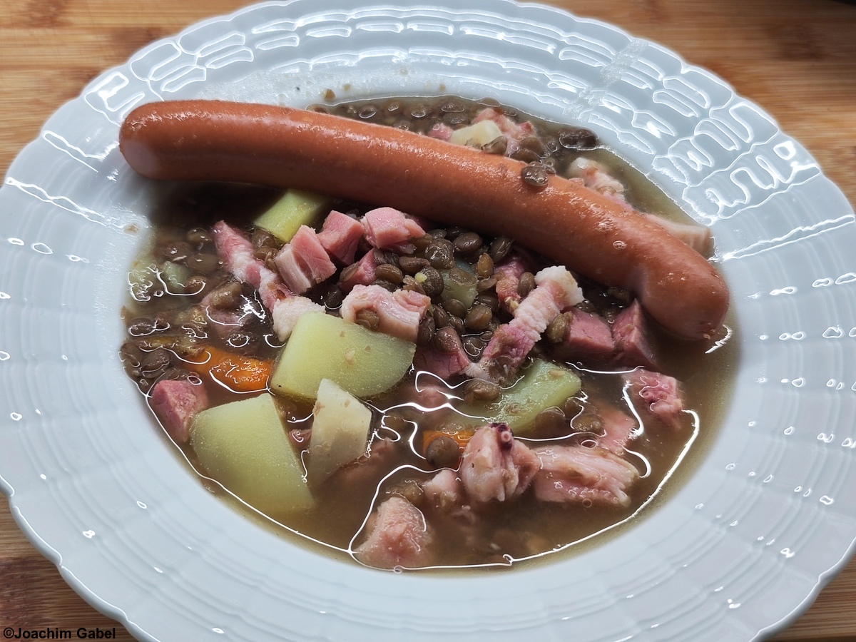 Since my lentil soup also contained knuckle meat and bacon, one sausage was enough for me.Da bei meiner Linsensuppe noch Haxenfleisch und Speck mit drin waren, reichte mir ein Würstchen.